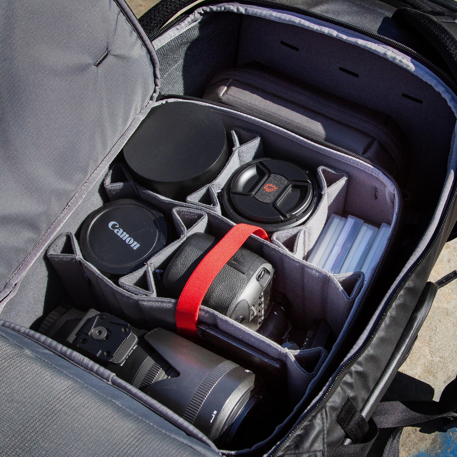 Camera bag with compartments for camera equipment, including lenses and a Canon logo.