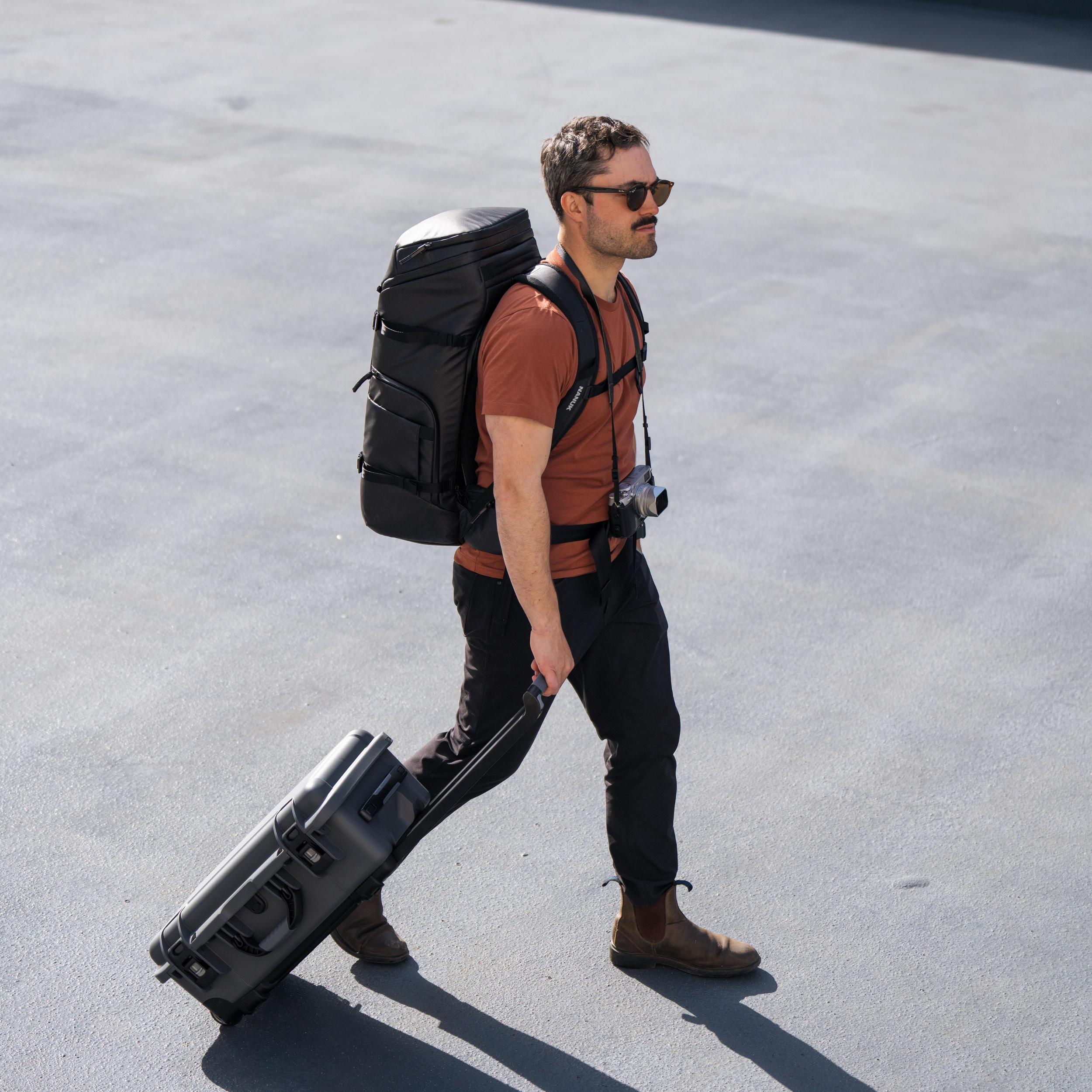 Guy walking down the street with NANUK 935 and NANUK Backpack