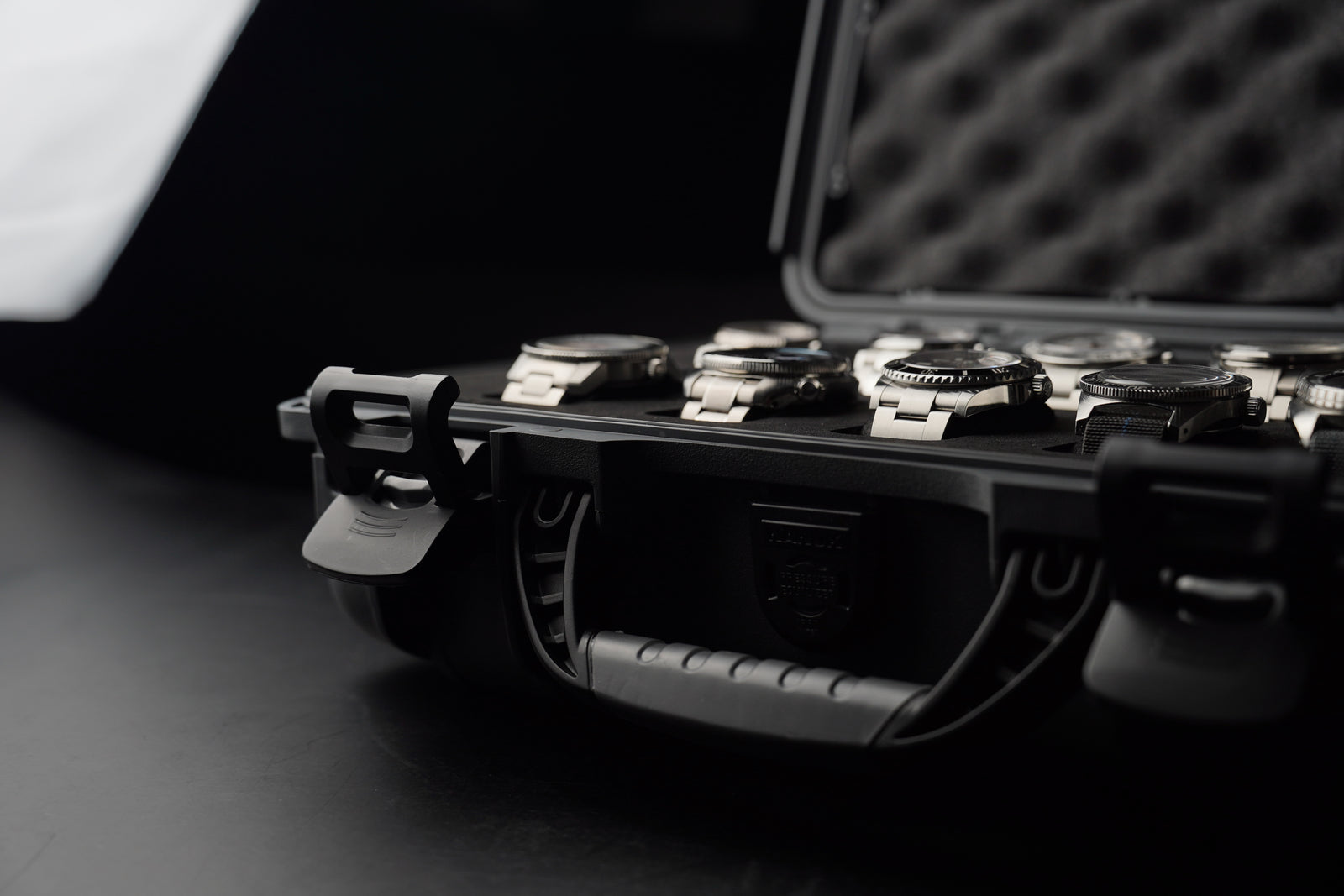 Black briefcase with watches on a dark surface