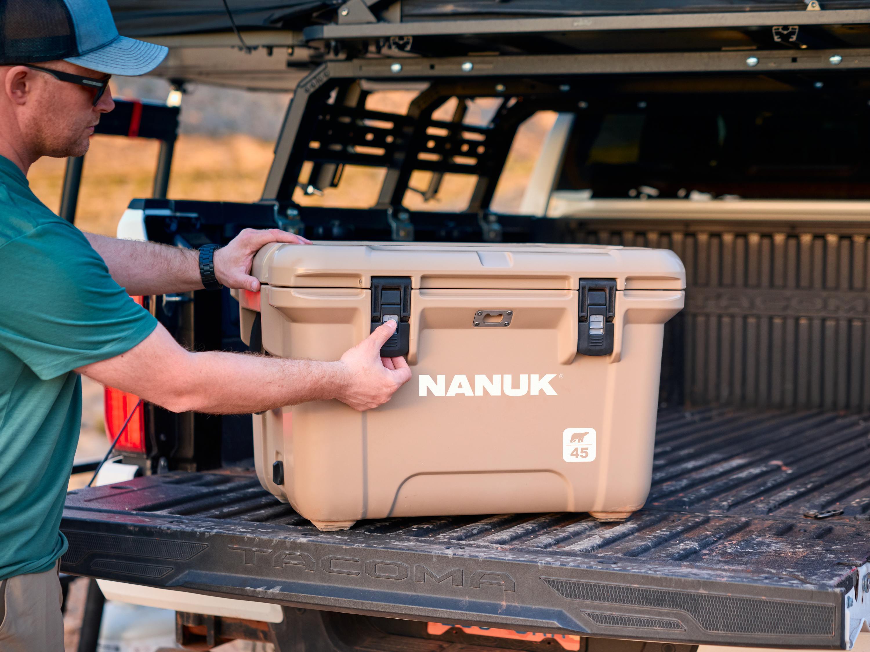 Person placing a Nanuk cooler box in the back of a truck
