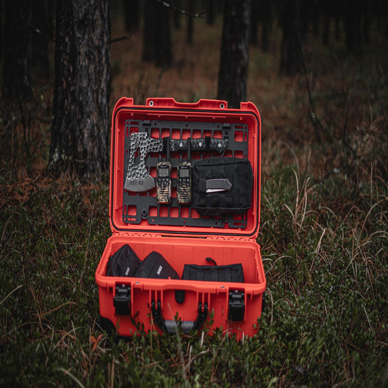 Open red tool case with tools on a grassy ground
