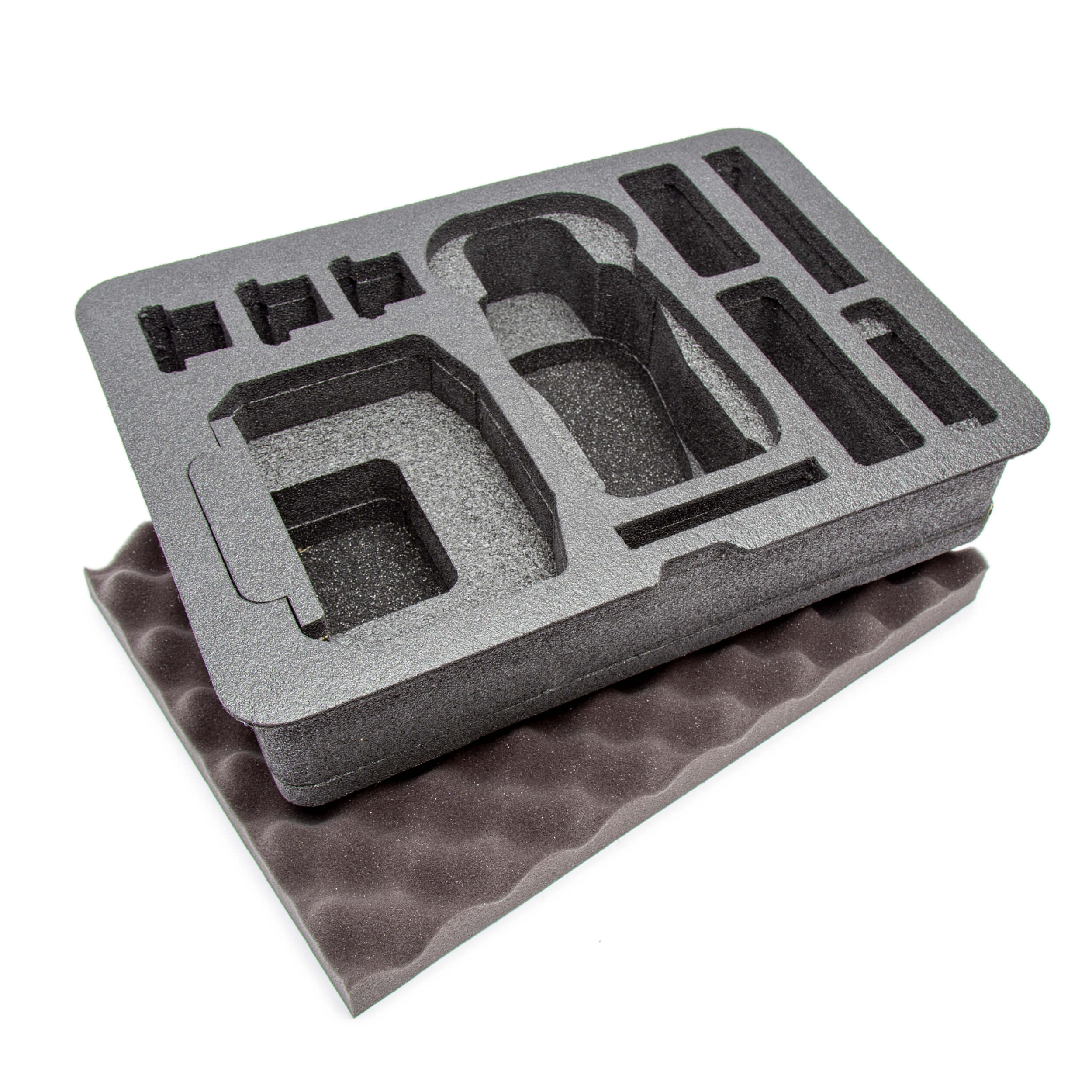 A gray foam insert for a NANUK 925 DJI Mavic 3 Pro Fly More case, pre-cut with compartments for gear and accessories, placed on top of an eggshell foam piece. A gray foam insert for a NANUK 925 DJI Mavic 3 Pro Fly More case, pre-cut with compartments for gear and accessories, placed on top of an eggshell foam piece.