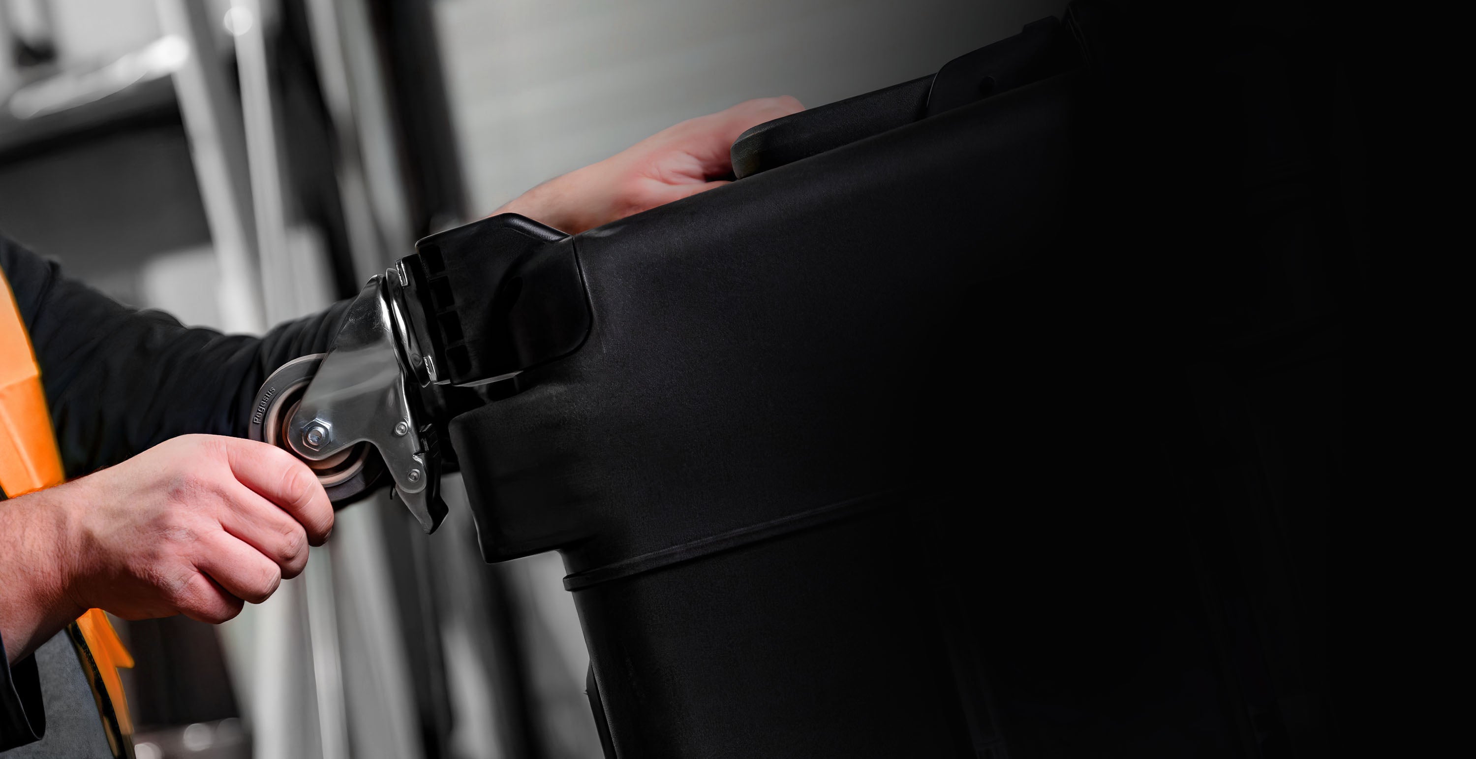 Men in a warehouse setting up wheel on a NANUK 975 Hard Cases
