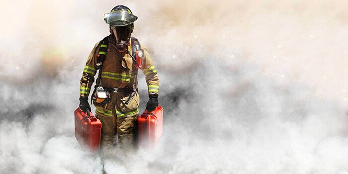 Fireman walking in smoke with 2 Nanuk cases