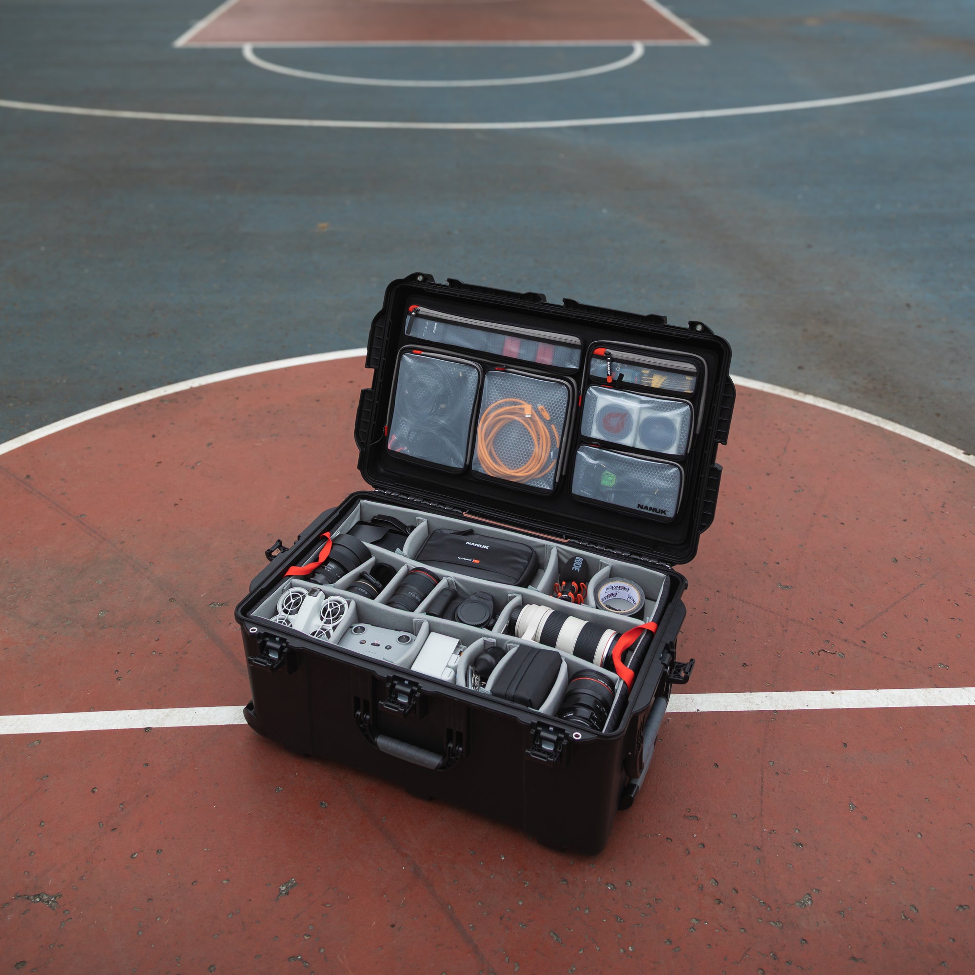 NANUK 965 Camera Case - Pro Photo Kit on a basketball court outside.