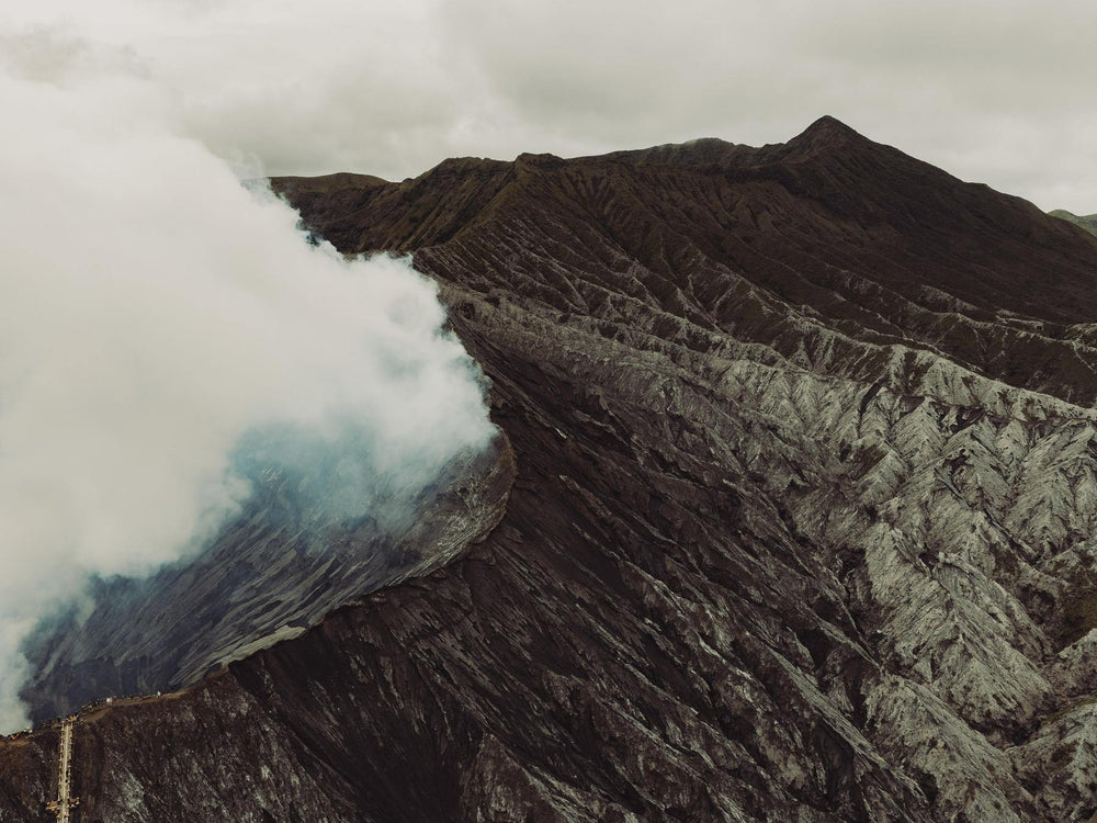 Volcanic landscape with smoke rising from a crater