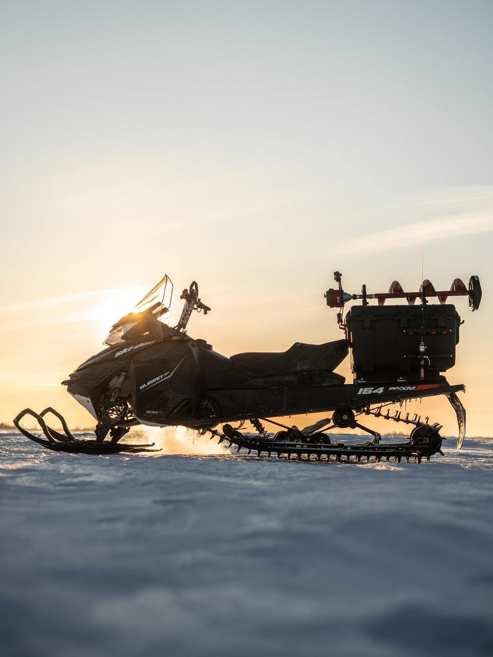 Snowmobile on a snowy landscape with a sunset sky