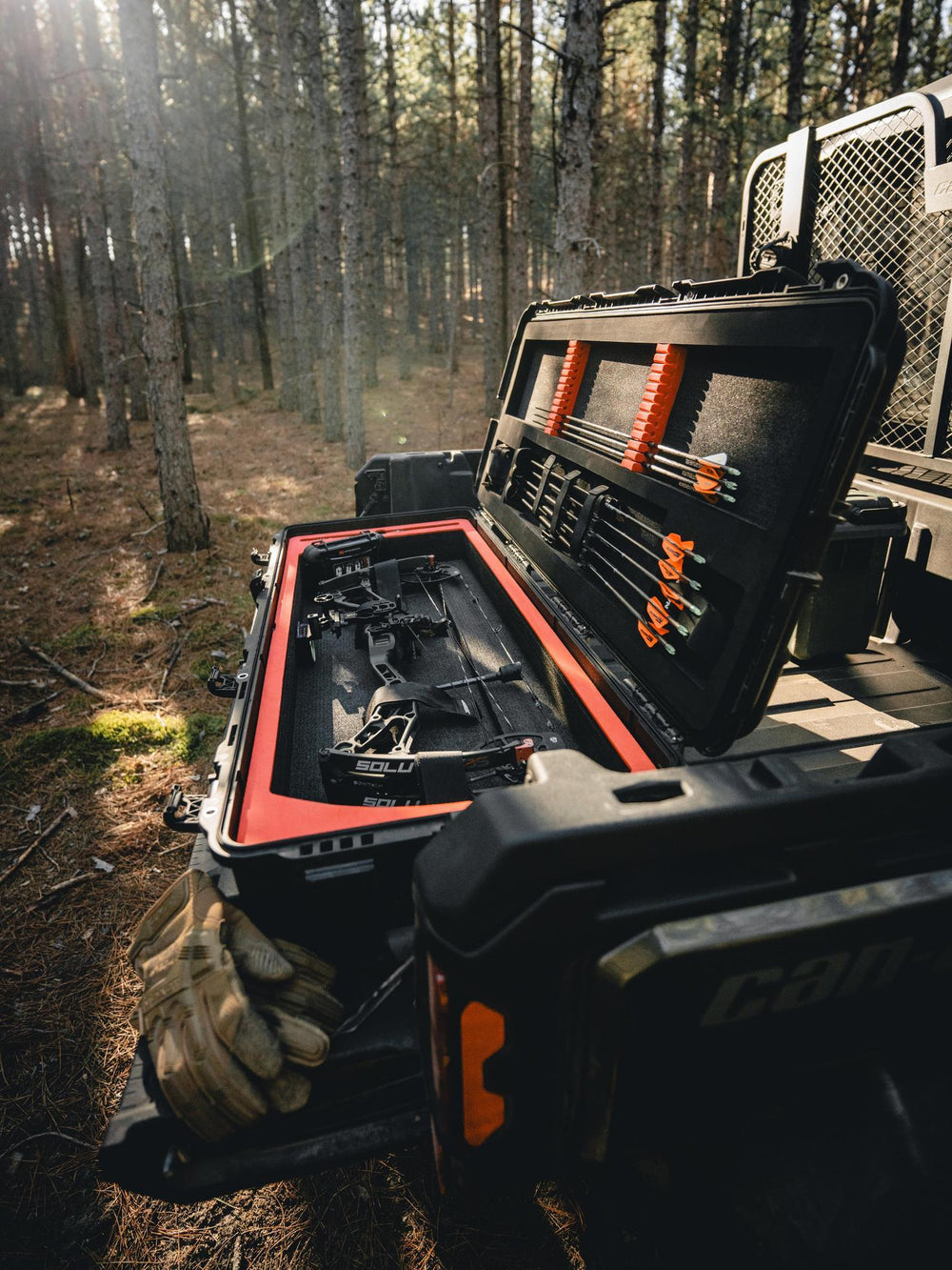 Bow case with arrows in a truck bed in a forest setting