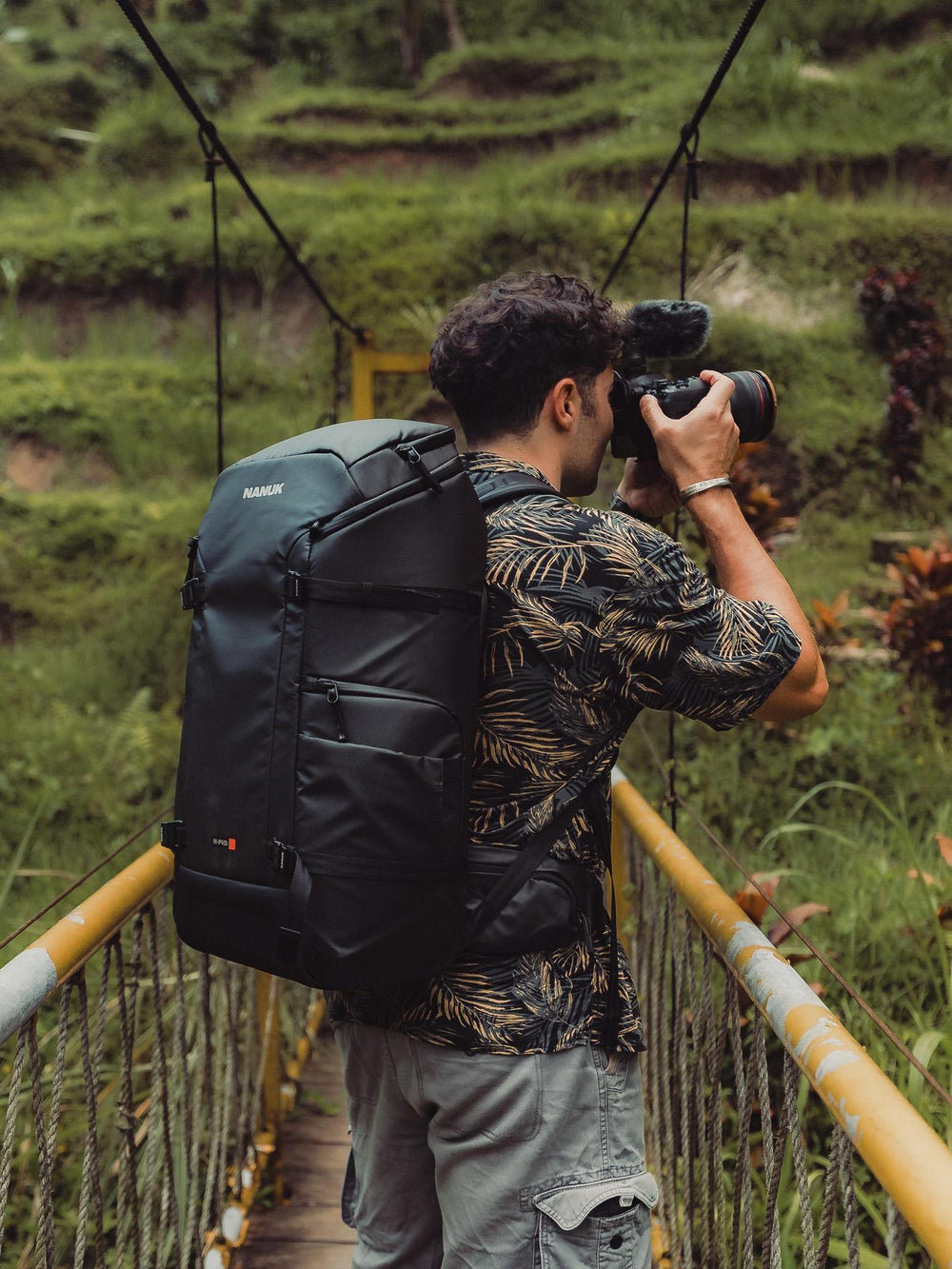 Person with a backpack taking a photo in a natural setting