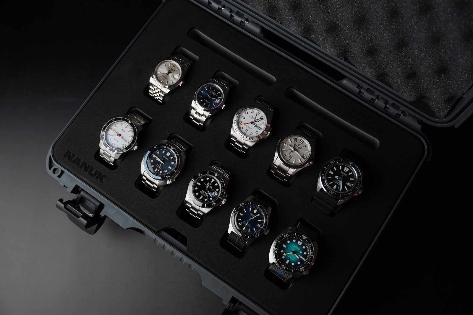 Set of watches in a black display case on a dark background