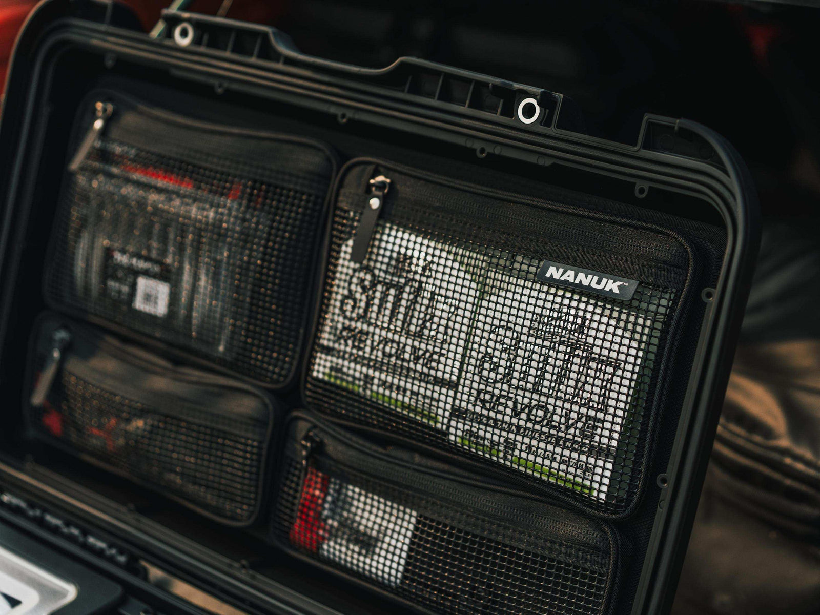 Black Nanuk pouch with multiple compartments and visible branding.