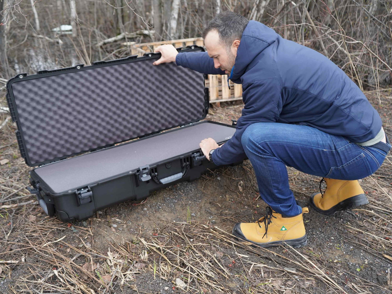 Person opening a large black protective case outdoors
