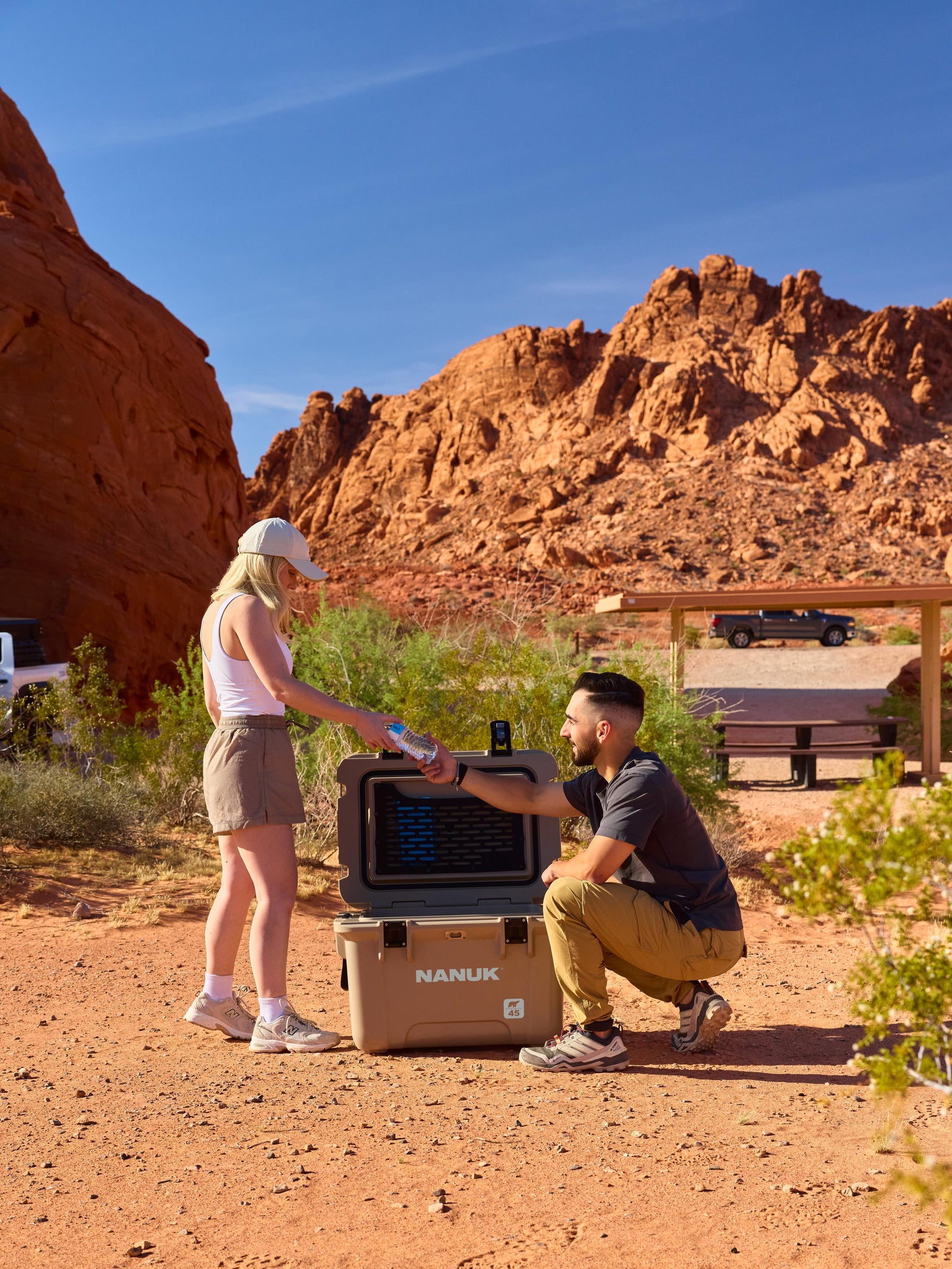 Two people with a Nanuk cooler in a desert setting