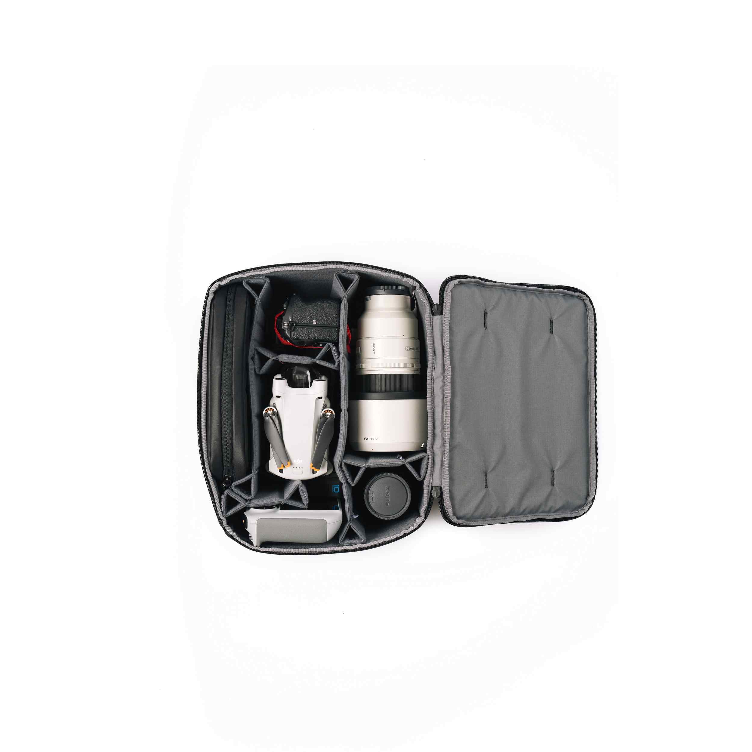 Open black travel case with silver and black items on a white background