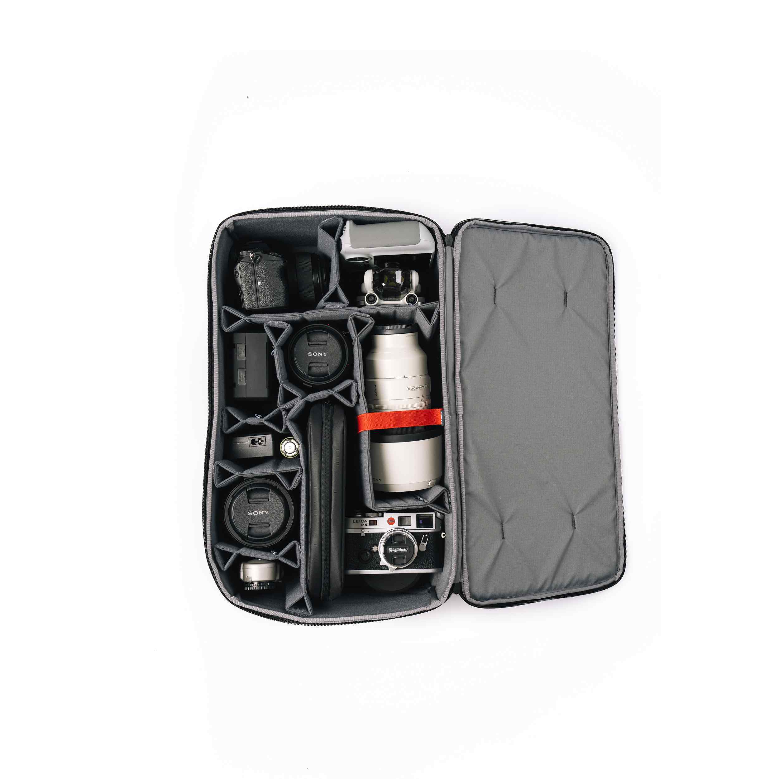 Camera equipment organized in a gray carrying case on a white background
