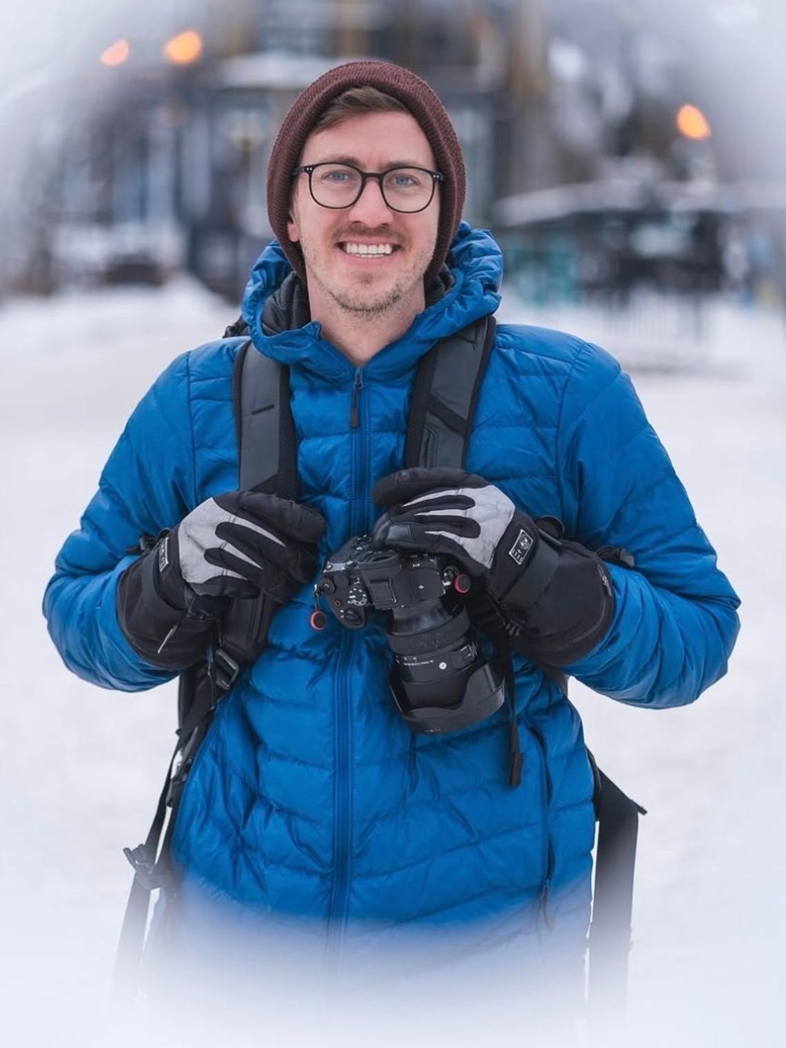 Person wearing a blue jacket and winter gear in a snowy setting