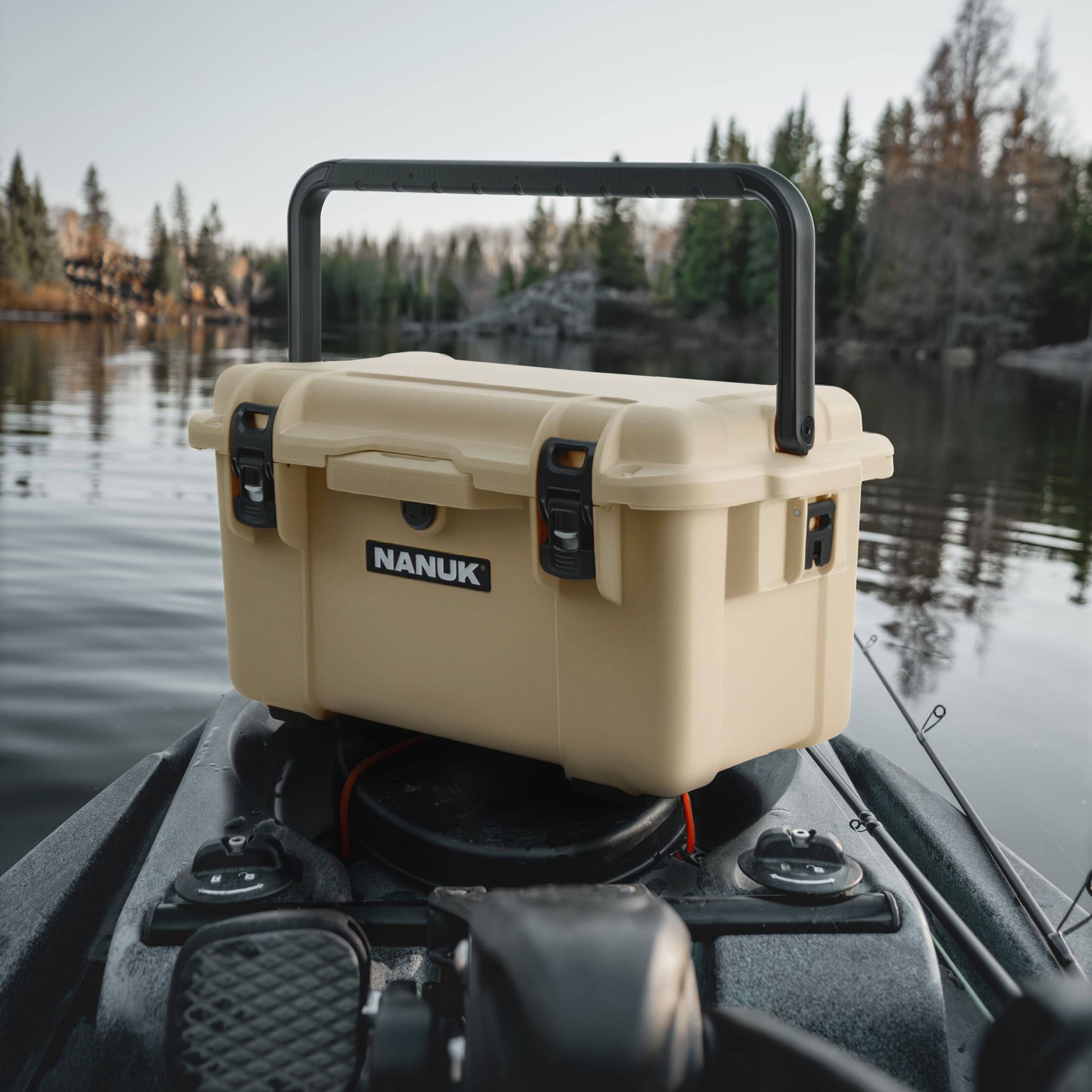 Nanuk cooler on a boat with a lake and trees in the background