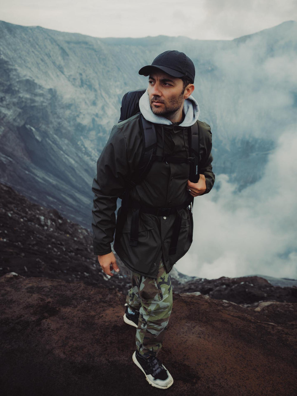 Person hiking on a mountain with a backpack and camouflage pants