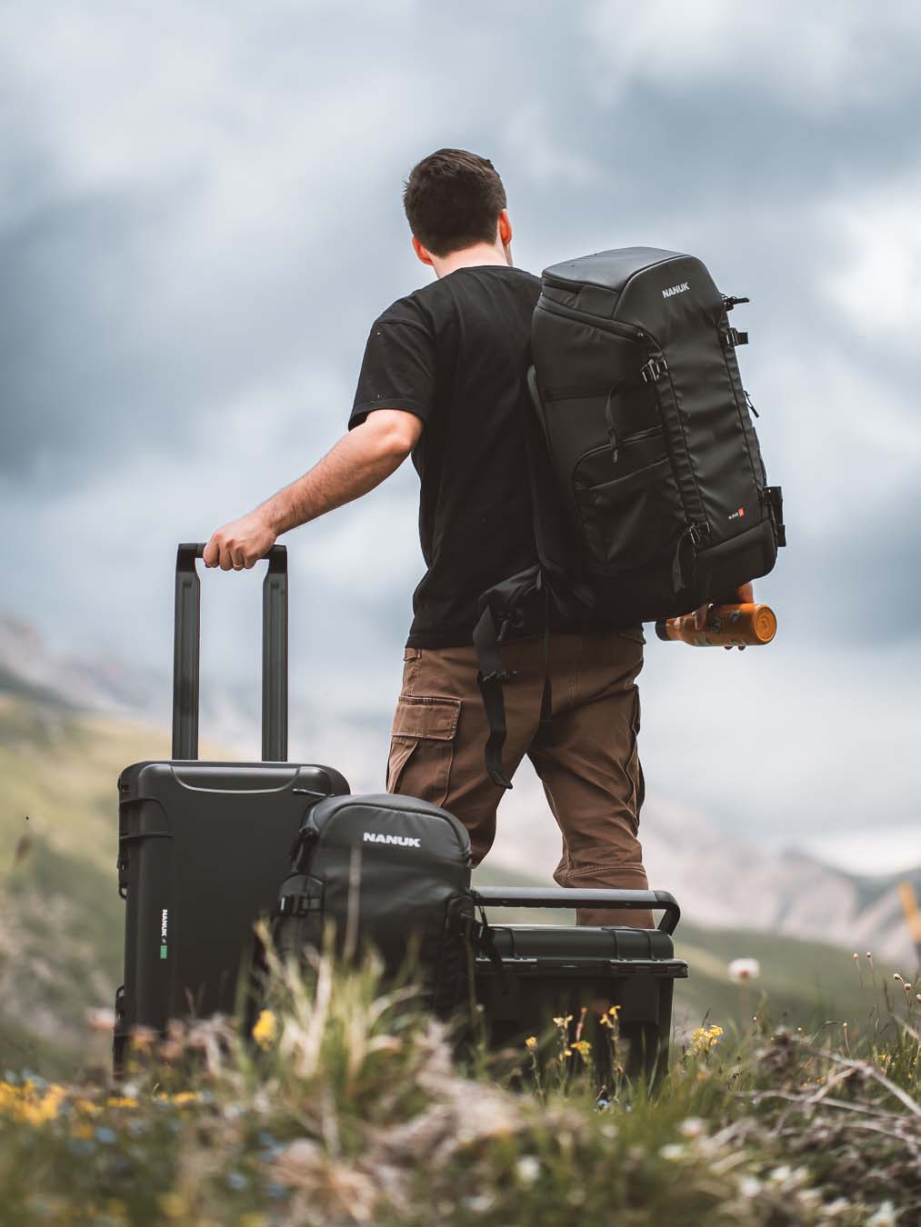 Professional Photographer looking at scenery with his NANUK Cases an Backpacks